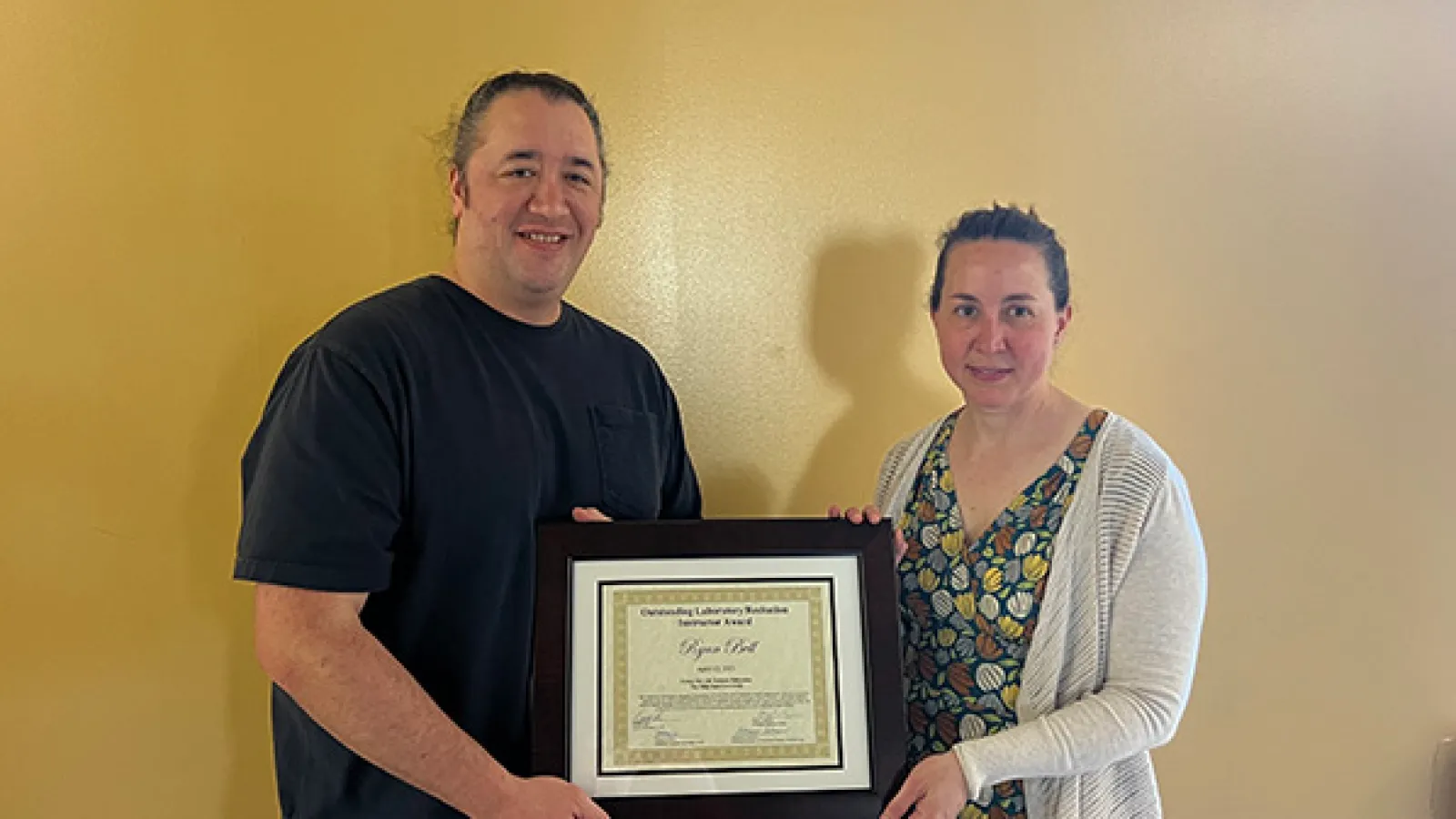 Ryan Bell is presented the award by Assistant Director Amy Kulesza