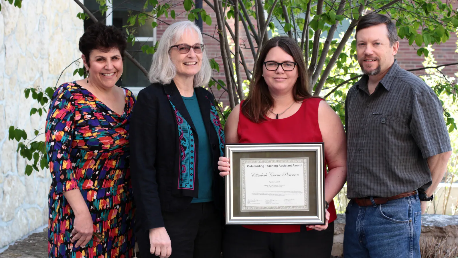 Corrie Pieterson receiving the TA award from Dr. Caroline Breitenberger, director, and assistant directors, Dr. Judy Ridgway and Matt Misicka