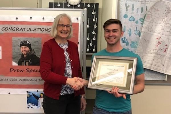 Caroline Breitenberger congratulates 2018 CLSE Outstanding TA Drew Spacht with a handshake and certificate